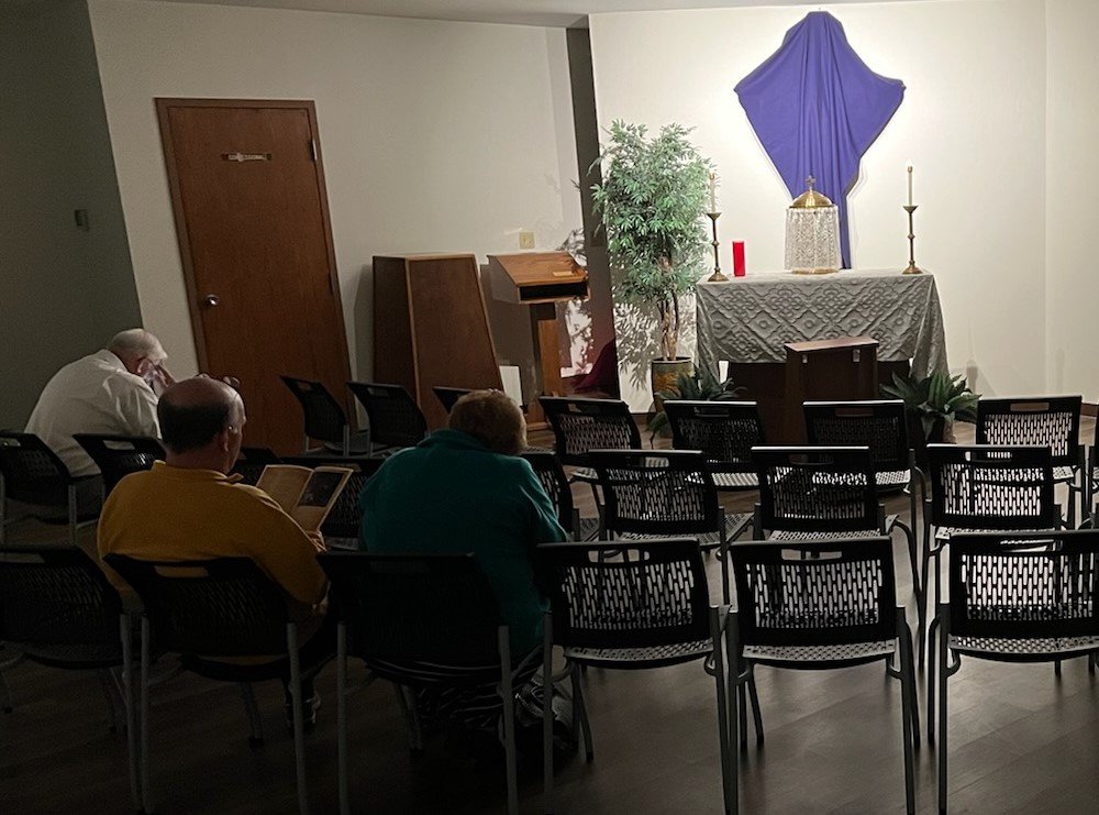 People visit the altar of repose in the chapel of St. Andrew Church in Holts Summit.